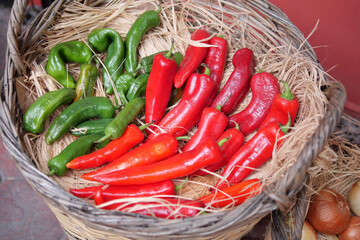 Colorful assortment of fresh peppers in a woven basket at market