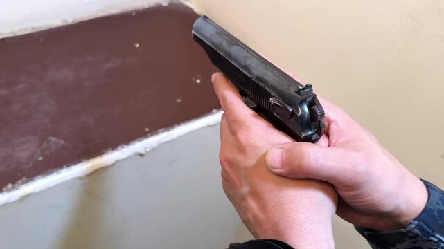 A man holds a Makarov pistol in his hands. Firearms of police officers in the CIS countries.
