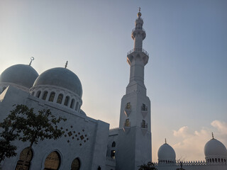 a mosque with magnificent and elegant architecture. The mosque is dominated by white, with round...