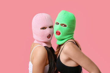 Beautiful young stylish women in balaclavas and sexy underwear on pink background