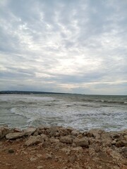 a seascape taken from a high vantage point, possibly from the shore or a cliff. At the bottom of...