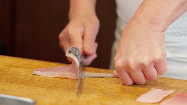 ホウボウを皮を剥ぐ寿司職人の手元