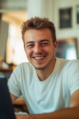 Obraz premium Happy Young Man Smiling at Laptop
