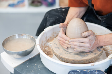 The potter kneads the clay before using it on the potter's wheel. Close-up of a man's hands. 