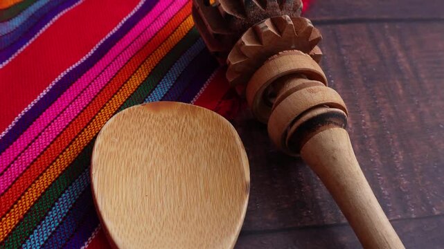 Mexican kitchen utensils, spoon and chocolate grinder, with Mexican tablecloth