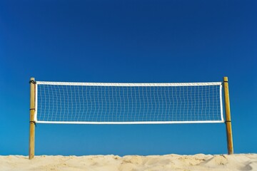 A simple beach volleyball net stands against a clear blue sky, set on a sandy beach, evoking a sense of fun and relaxation.