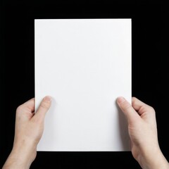 Closeup of hands holding blank white paper on black background