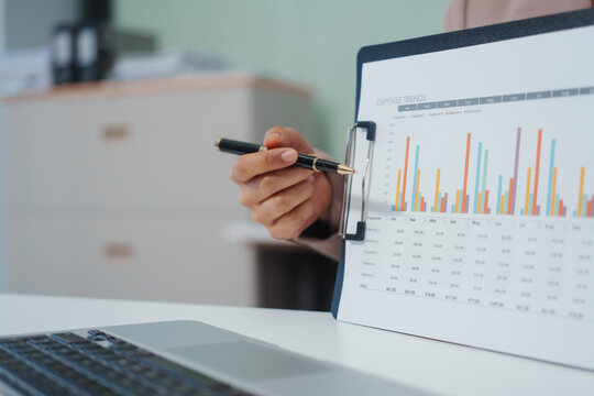 An Asian businesswoman accountant calculates invoices, taxes, interest, loans using a calculator,working online to guide clients through financial planning ensure a smooth loan process for success