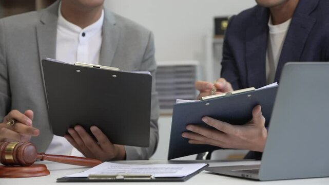 A businessman and a male lawyer or a team of judges discuss a joint investment meeting. They provide legal advice, review contracts, and ensure compliance with business laws and regulations