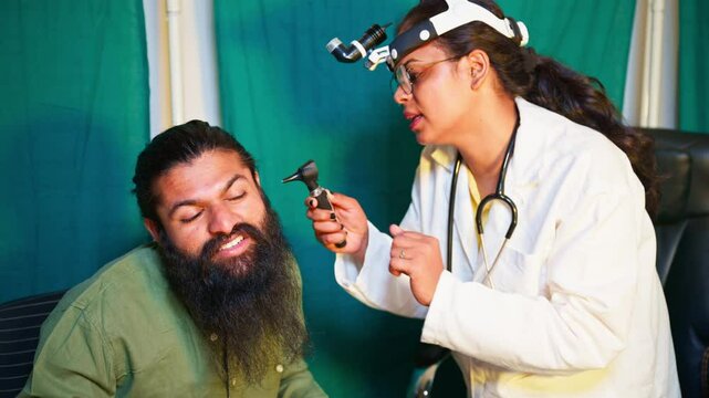 Lady surgeon checks male sufferer hearing at hospital
