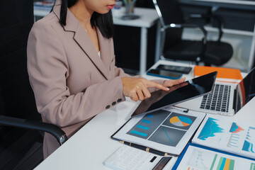 An Asian businesswoman accountant calculates invoices, taxes, interest, loans using a...