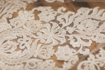 Close-Up of Intricate White Lace Fabric with Floral Embroidery Pattern


