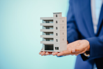 A female employee works at her desk in a real estate office, managing condo sales in the city. She...
