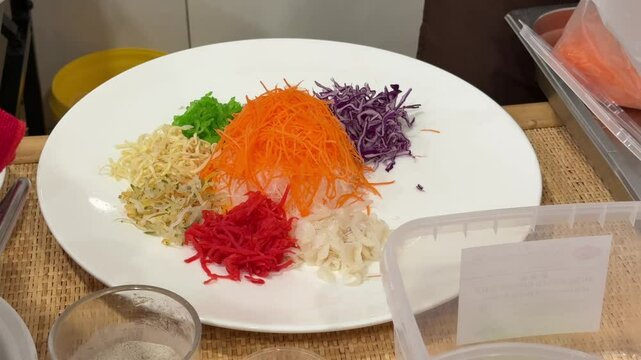 A close-up of a chef preparing the ingredients of yusheng, yee sang or yuu sahng or Prosperity Toss in a Malaysian restaurant