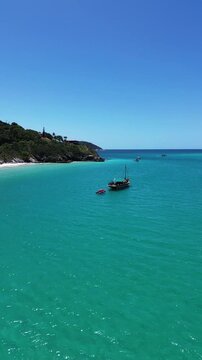 Escuna with people in crystal clear Caribbean waters of Brazil, Pontal do Atalaia - Arraial do Cabo