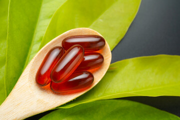 wooden spoon with soft gels, Fish oil capsules, omega 3, omega 9, vitamin D, vitamin E