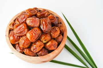 Dates fruit sukari or kurma sukari, in wooden bowl isolated on white background