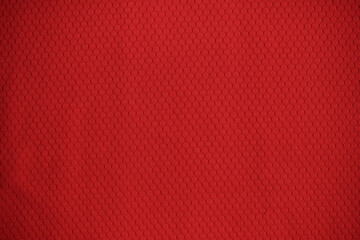 Texture of red jersey clothing fabric. Flatlay style, close up, studio shot. Sport background. Fabric commonly used for sportswear as football, basketball, volleyball, hockey, rugby etc