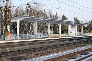 Russia, Chelyabinsk region, Kisegach station, February 21, 2025: Empty railway track and empty passenger platform, winter landscape.