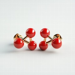 Obraz premium Two red earrings with gold posts