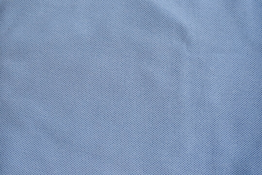Texture of turquoise blue cotton pique fabric. Flat lay style, close up. Commonly use for t- shirt. Woven fabric characterized by a pattern of raised parallel cords or geometric designs. 