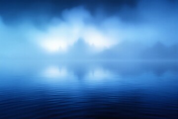 Obraz premium Calm blue lake with misty mountains in the background.