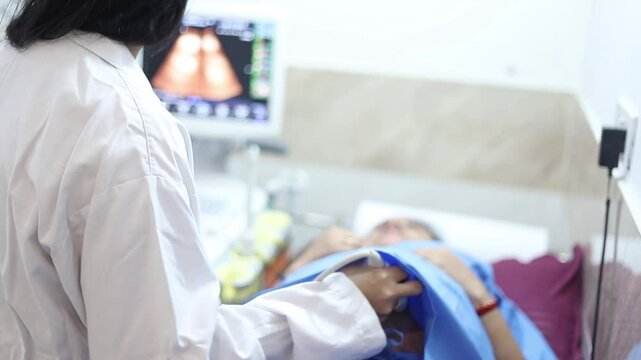 Indian doctor doing ultrasound scan for pregnant woman in hospital. Gynecologist doin pregnancy checkup to check the fetus or baby health.