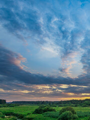 Fototapeta premium Beautiful blue sky with a few clouds and a sunset in the background