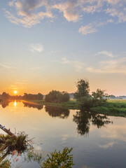 Beautiful sunset over a river with trees in the background