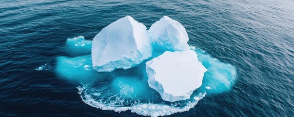 Iceberg melting concept. Aerial view of stunning icebergs floating in clear ocean waters, showcasing nature's beauty.
