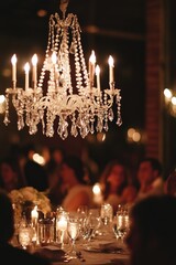 Crystal chandelier illuminates wedding reception dinner