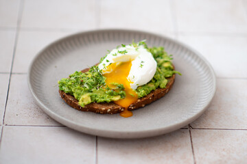 Mashed avocado and poached egg on wheat bread toast