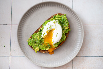 Mashed avocado and poached egg on wheat bread toast
