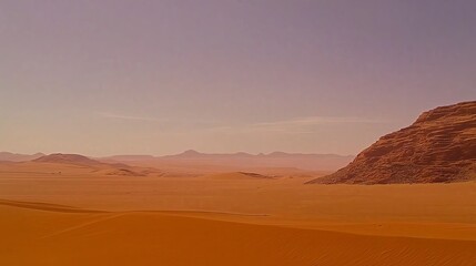 Naklejka premium A vast desert with only a single sand dune under a pale blue sky