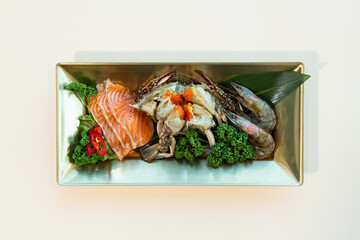 Japanese cuisine. Sashimi set with salmon, shrimp, fishpus, squid and mussels in a plate on black background.