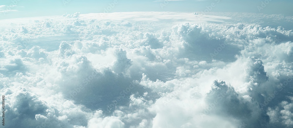Aufkleber Fluffy white clouds scattered across a bright blue sky with soft sunlight illuminating the scene from above creating a serene atmosphere.