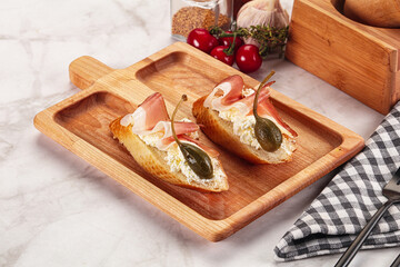 Bruschetta with jamon and caper berries