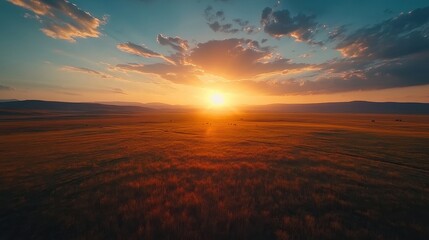 Fototapeta premium Captivating sunset over vast grassland with dramatic sky and rolling hills