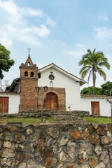 Obraz premium Colonial church with brick facade and palm trees.
