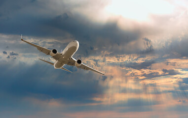 White passenger airplane flying in the sky amazing clouds in the background - Travel by air transport