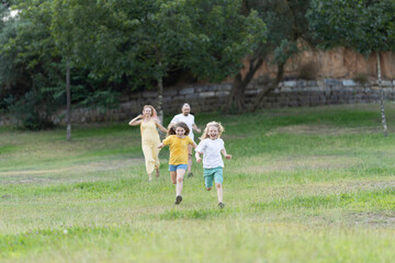 Fototapeta premium Happy family running and playing together in park