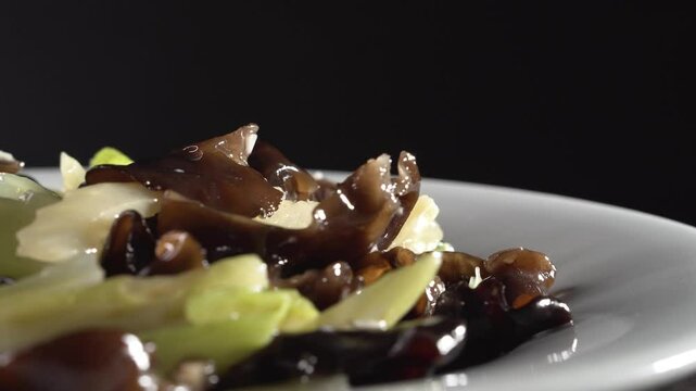 Stir-fried Celery with Wood Ear Mushrooms on black background. Food concept