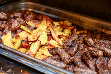 Potatoes and the popular kebabs made of ground beef and pork in a dish that keeps the heat ready to eat.