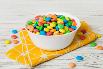 Multicolored candies in a bowl on a colored background. birthday and holiday concept. Top view with copy space