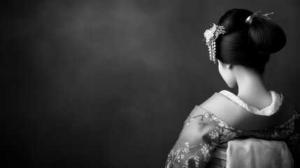 Stunning black and white portrait of a graceful japanese geisha viewed from behind in elegance