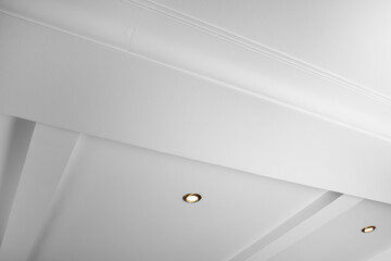 Suspended and grid ceiling with LED spots lamps and drywall construction in empty room in house...