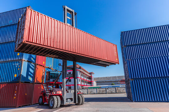 Truck forklift lifting loading heavy container cargo box at port container yard shipping logistics