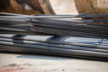 A pile of metal bars with a shadow on the ground