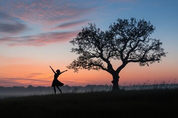 Fototapeta premium Ballerina is dancing at sunrise in a misty field near a lonely tree