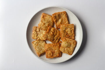 Fried tempeh in a white plate, one of popular street food from Indonesia.
